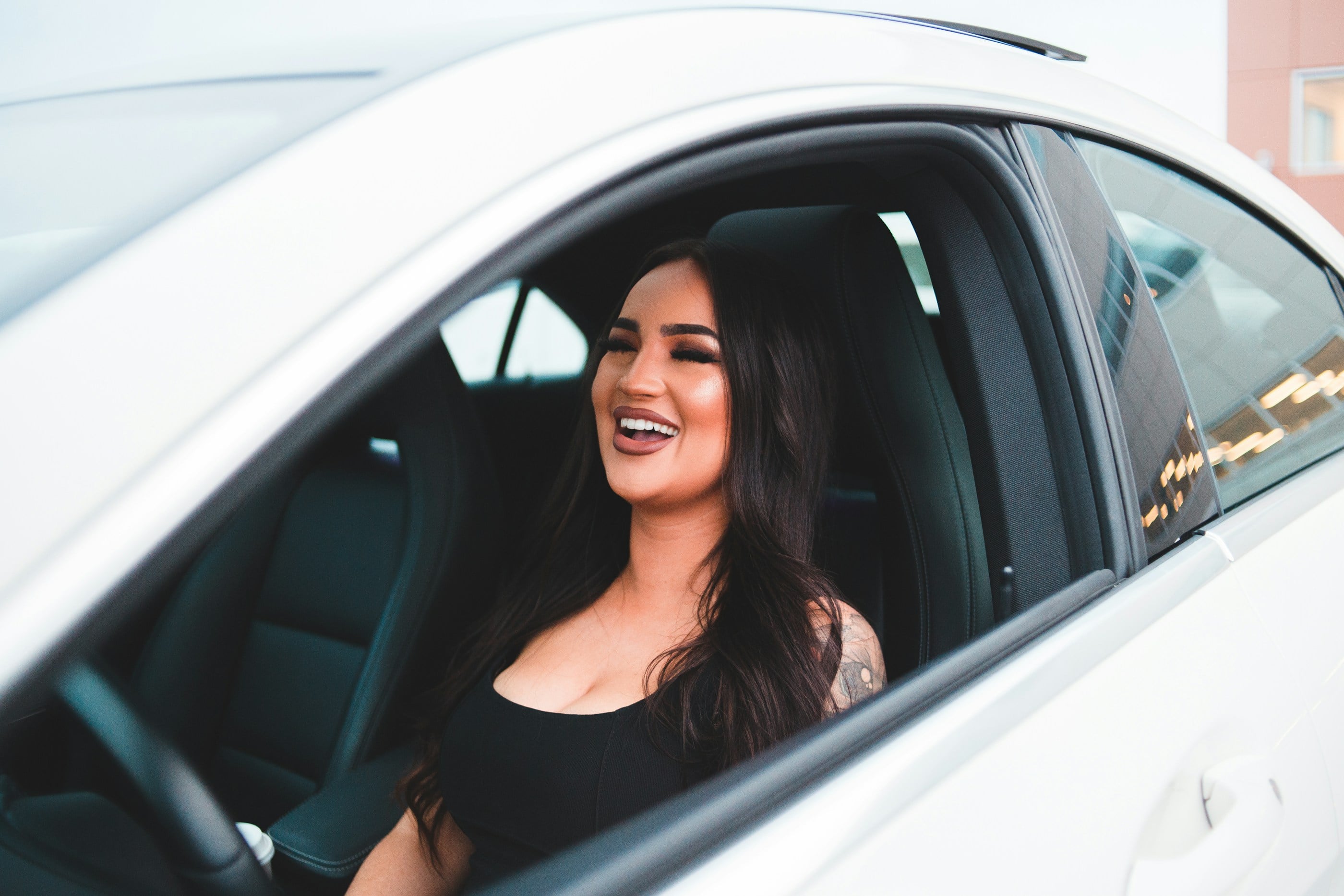 Smiling woman in the driver's seat of her car